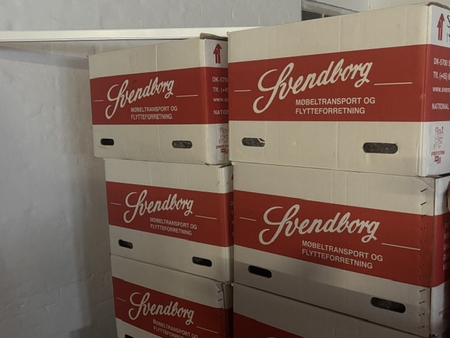 Flyttekasser med Svendborg-logo stablet klar til brug