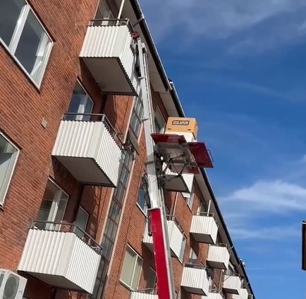Flyttehejs løfter møbler op langs facaden til en altan